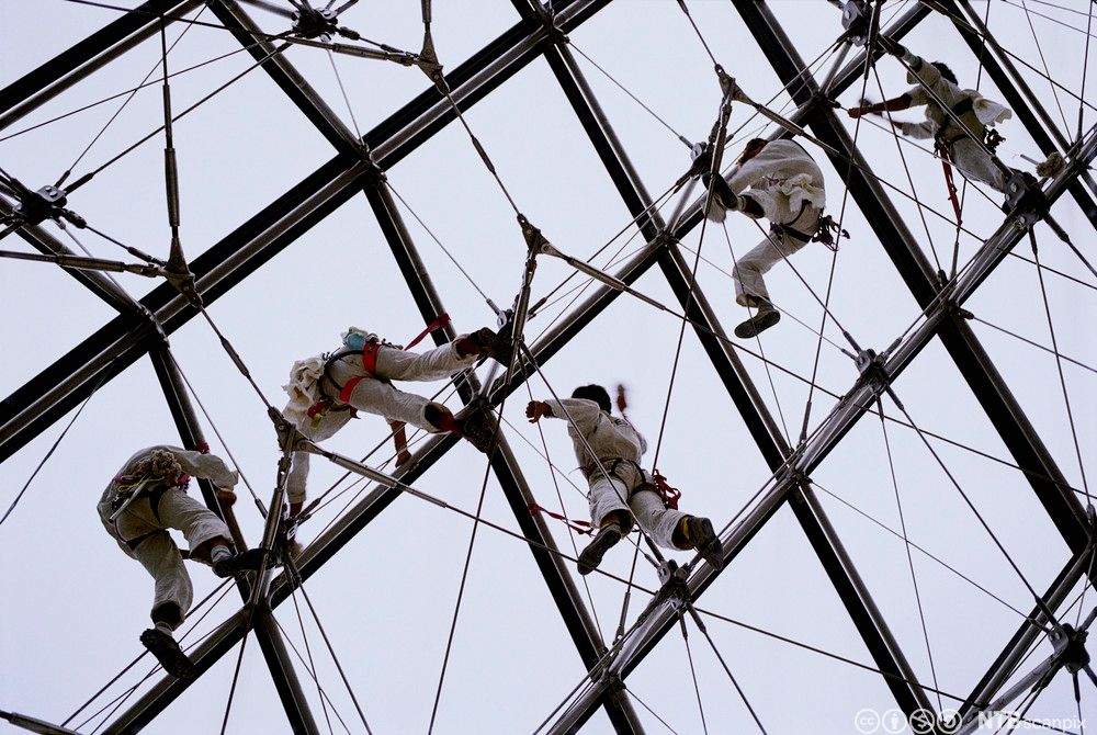 Arbeid og vask utføres på en glass- og stålkonstruksjon med mange vinkler. Foto.