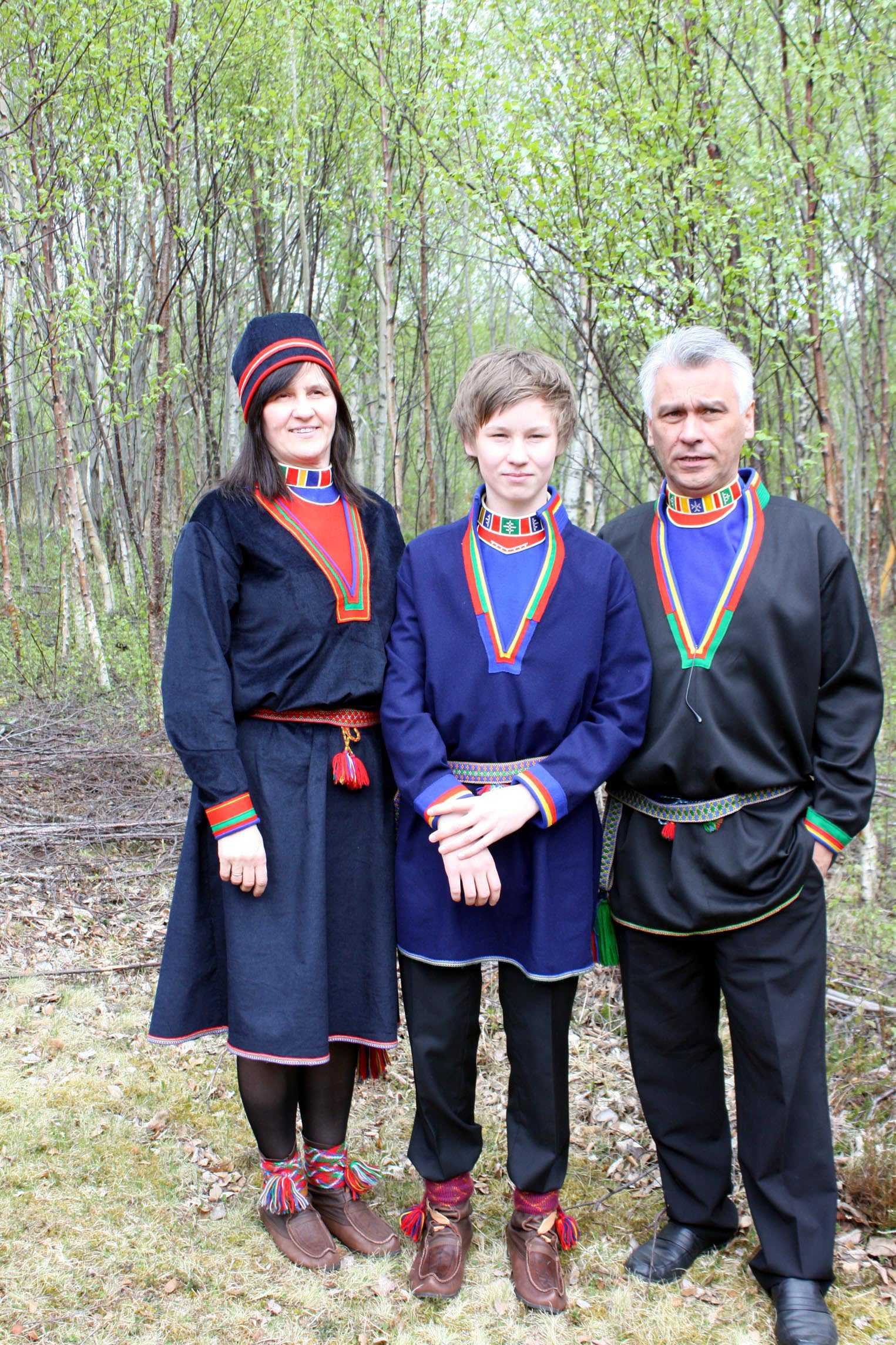 Foreldre og sønn med lulesamiske kofter. Foto.