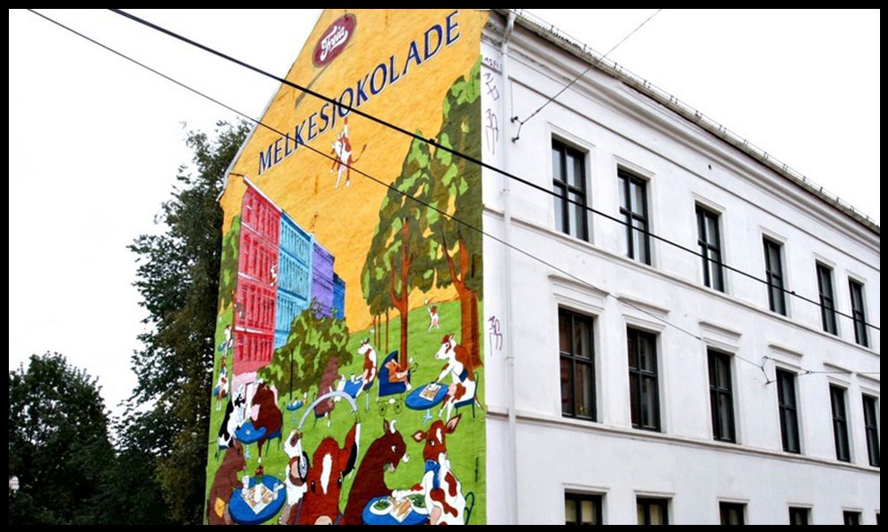 Reklame for melkesjokolade på husvegg. Foto.