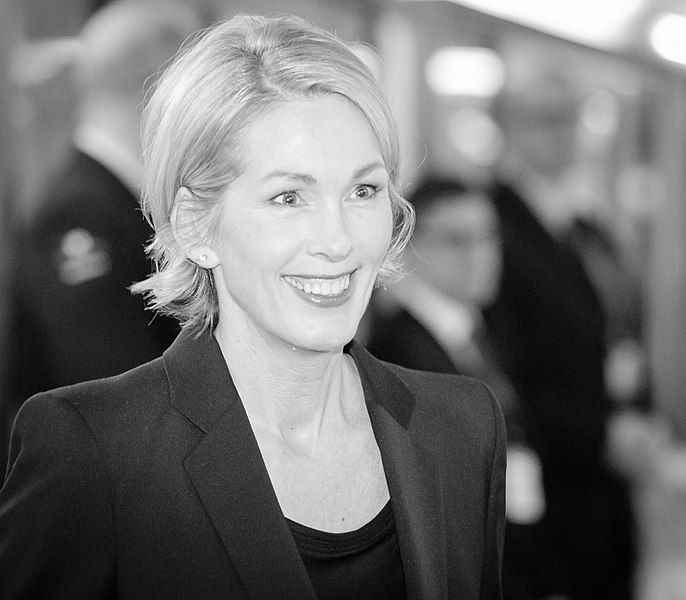 En smilende kvinne i et formelt antrekk. Foto.