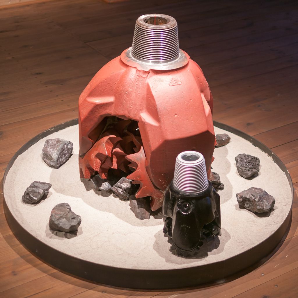 En borekrone til brønnboring. Den har tre kjegleformede deler som knuser bergarten under boring. Foto.