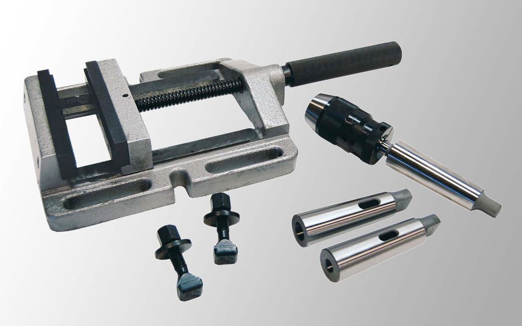 Skrustikke, to spormutrar, chuck og to reduksjonshylser. Foto.