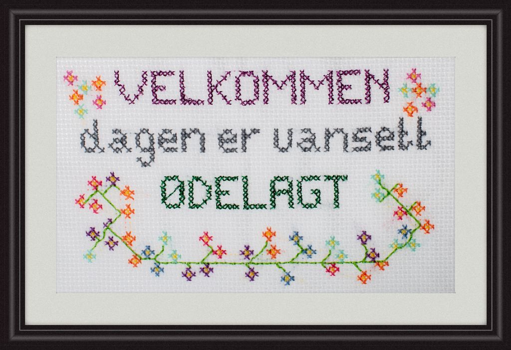 Geriljabroderi med teksten "Velkommen, dagen er uansett ødelagt". Foto.