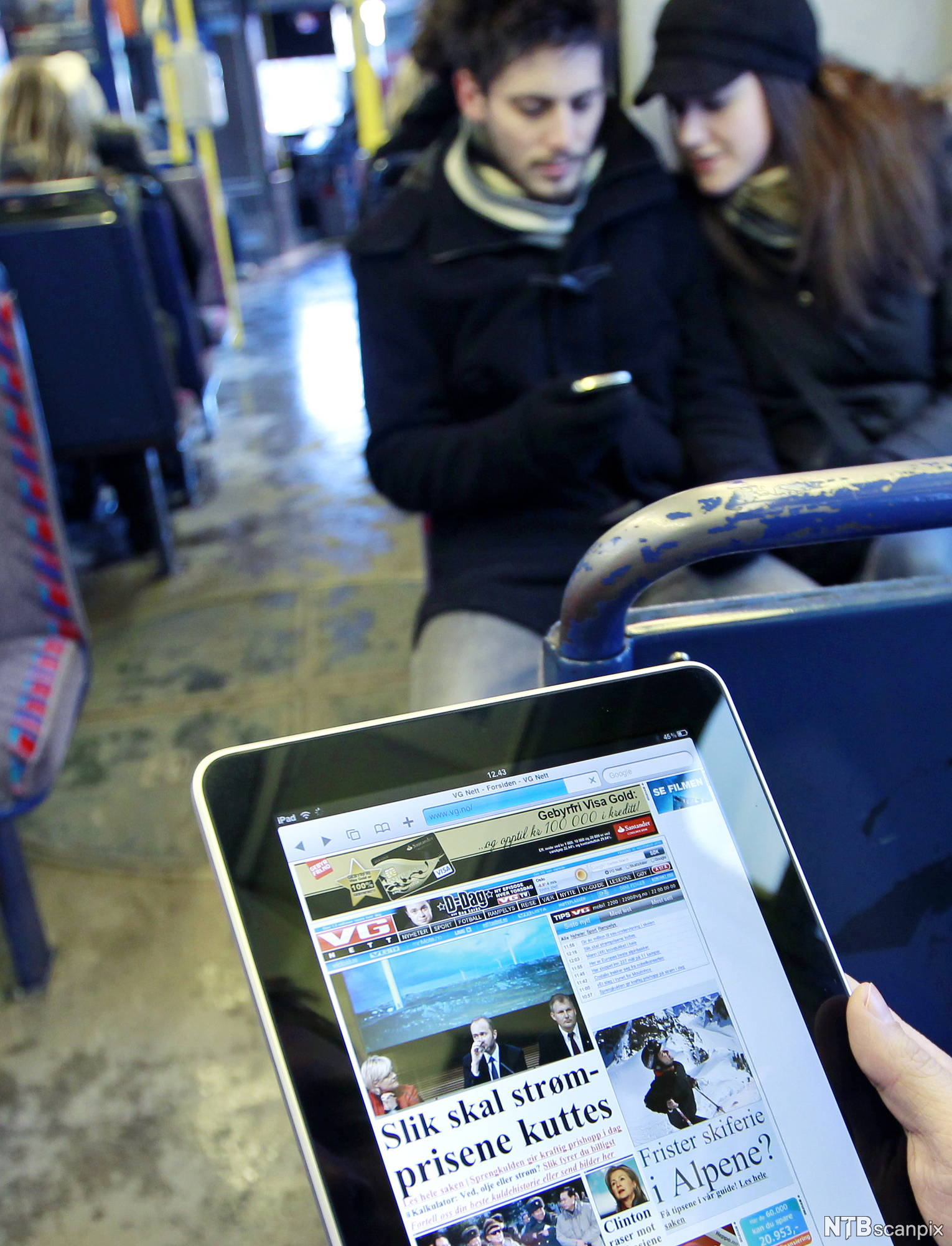 En person som leser nyheter på nettbrett på undergrunnen i Oslo. Foto.