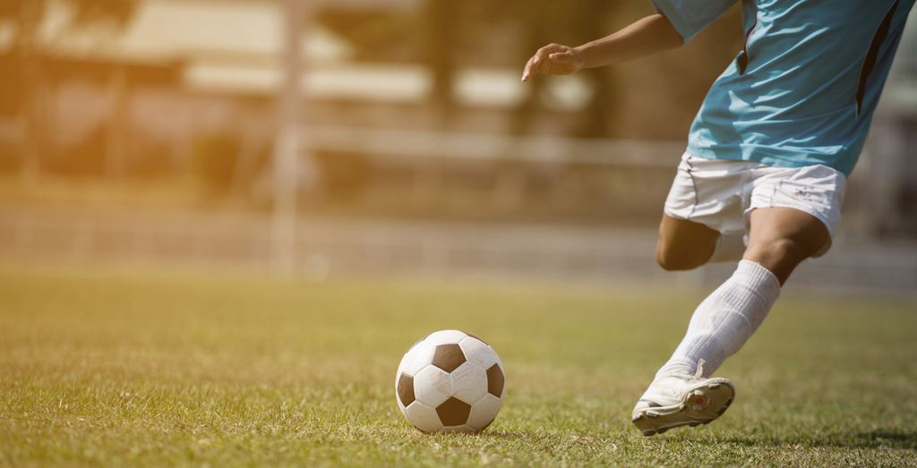 Fotballspiller i ferd med å sparke ein ball. Foto.