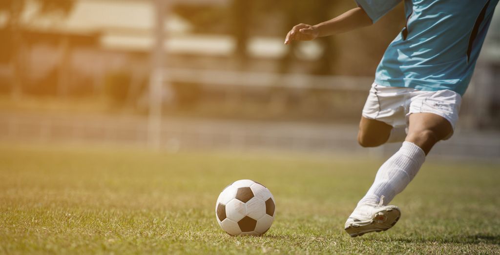 Fotballspiller i ferd med å sparke en ball. Foto.