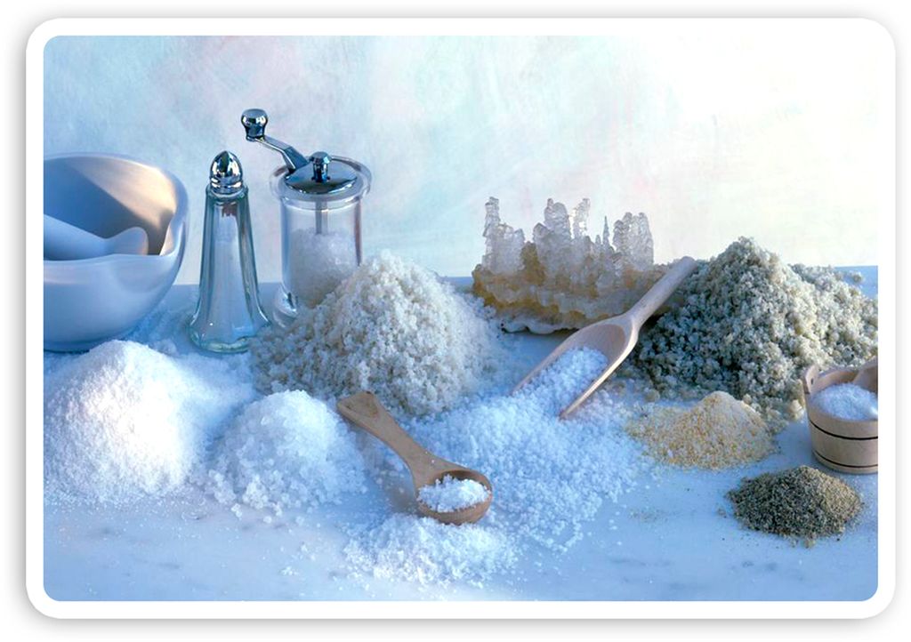 Ulike typer salt, saltbøsser og saltskjeer på et bord. Foto.