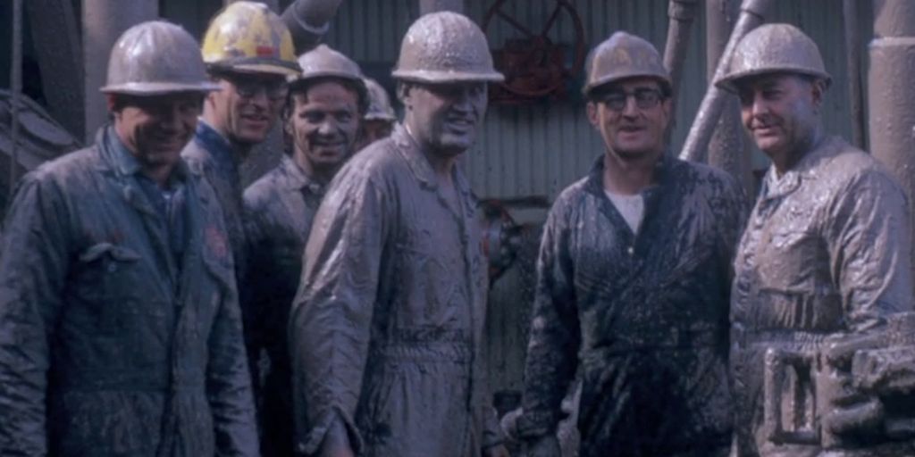 Tilgrisede, smilende oljearbeidere. Foto.