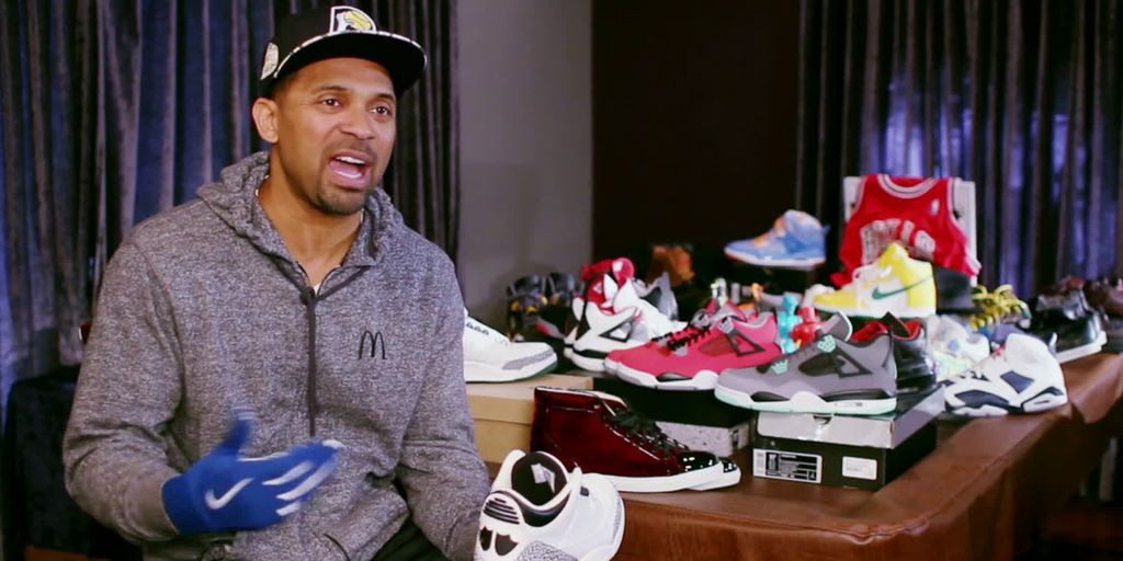 Bilde fra filmen Sneakerheadz. En mann holder en sko, og forteller. I bakgrunnen er det mange sko (sneakers). Foto. 