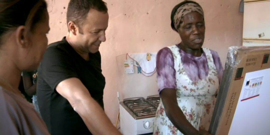 Tre personer snakker sammen mens de ser på et bilde. Foto.