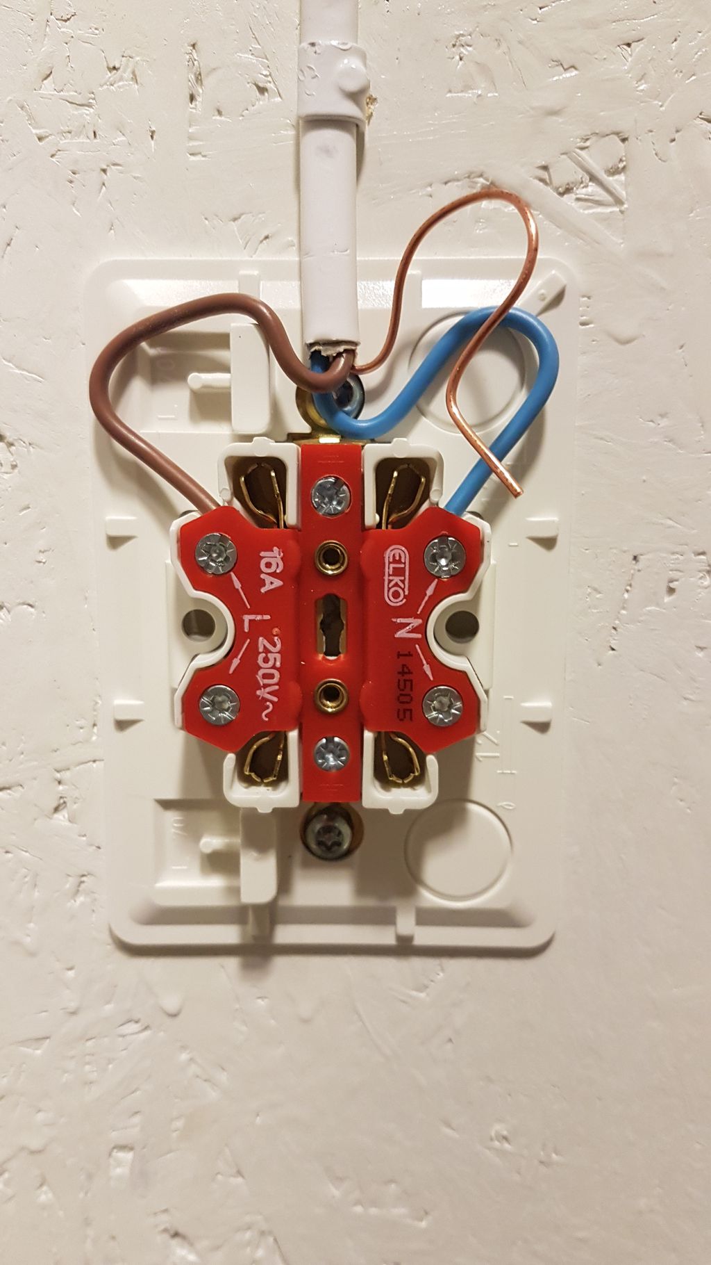 En åpnet stikkontakt der jordlederen ikke er koblet til. Foto.