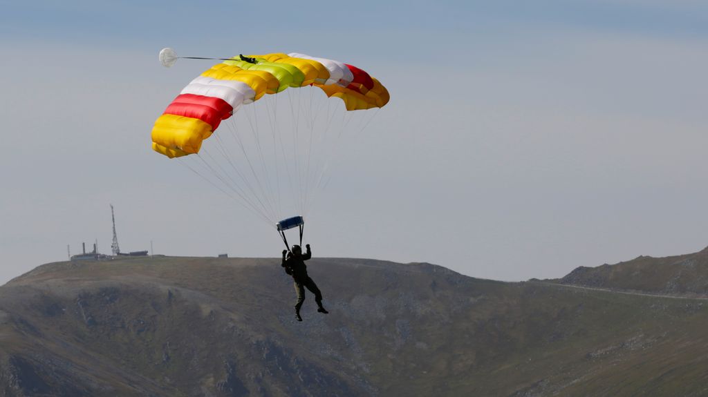 Person i fallskjerm går inn for landing. Foto.