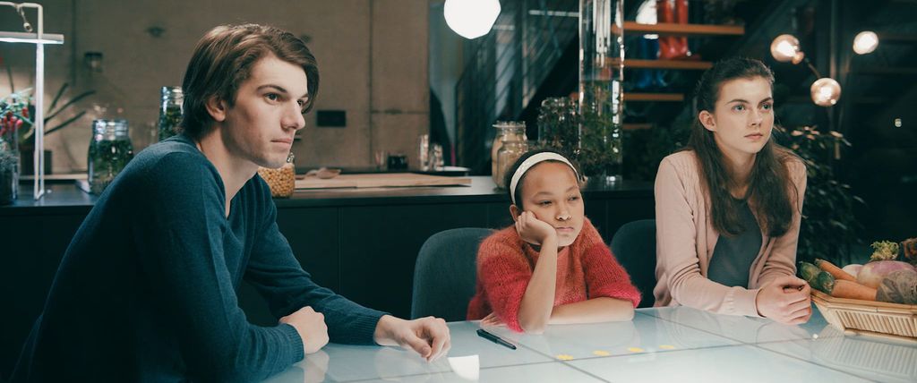 Tre unge ved et bord. Foto.