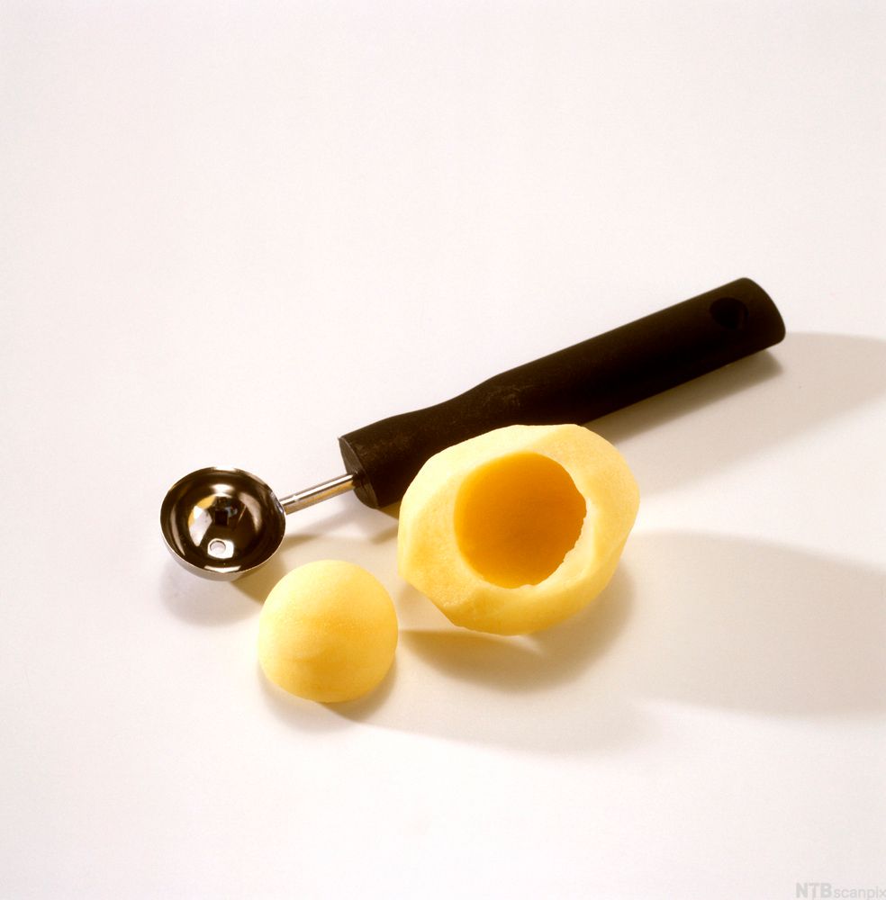 Et pariserjern og en potet hvor det er tatt ut ei kule. Foto.