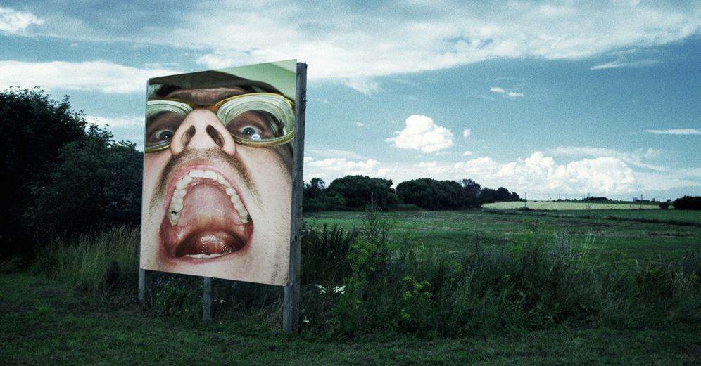 Fotografi av reklameplakat i åpent landskap.