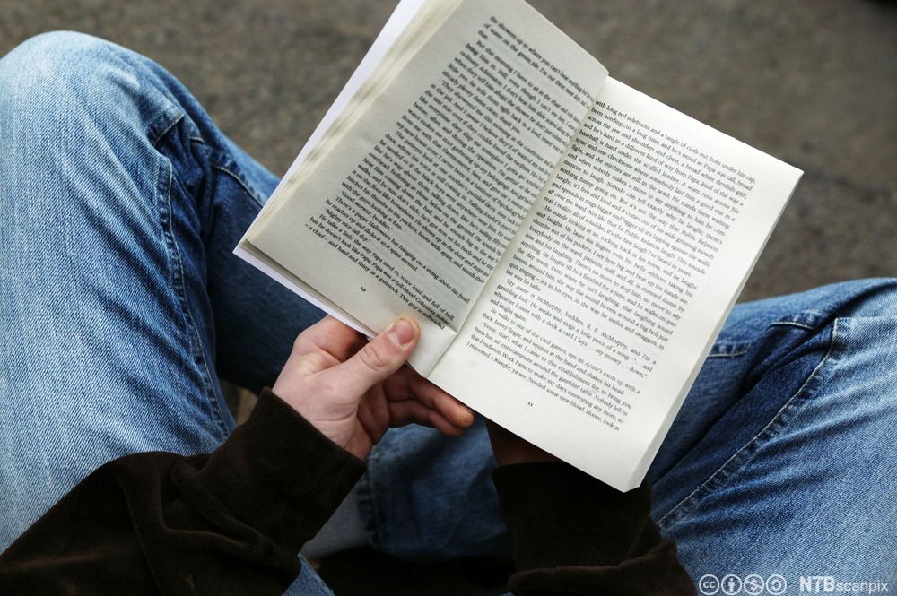 Ung mann leser bok. Foto.