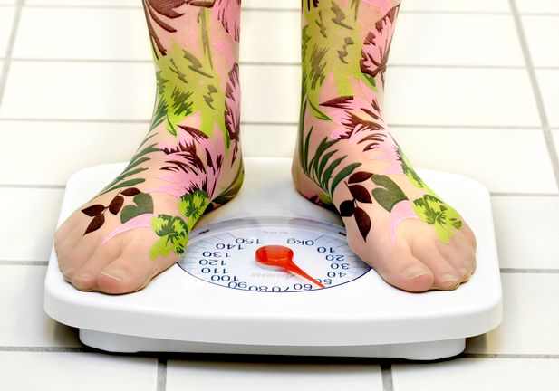 To føter på ei badevekt. Foto.