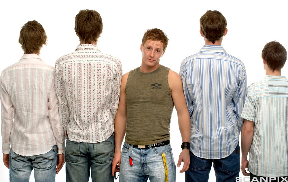 Fire menn med lyse skjorter står med ryggen til og en mann med singlet står vendt fram. Foto.