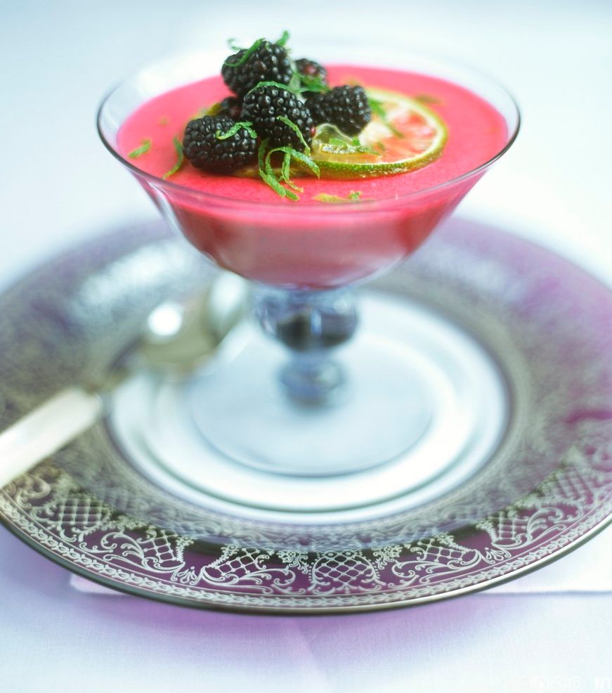 Rosa bjørnebærmousse i glass med hele bjørnebær og limezest som garnityr. Foto.