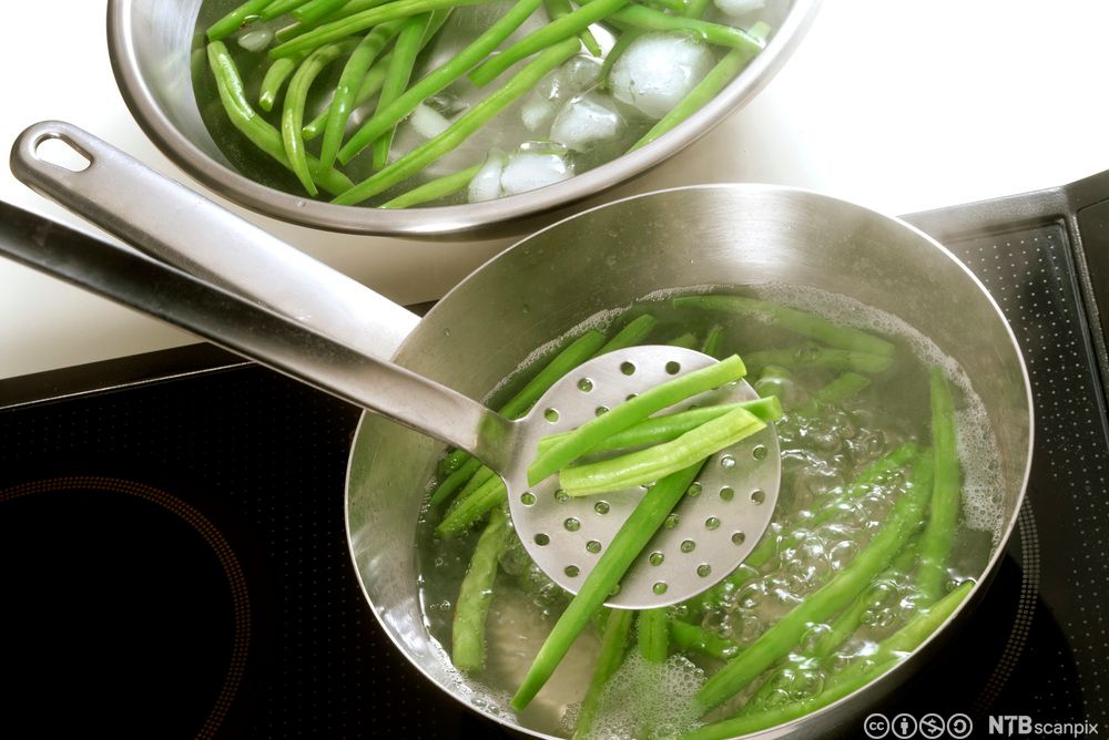 Bønner blansjeres i ei gryte. Foto.