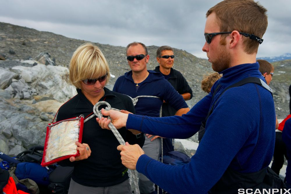 En gruppe turister på brevandring passes på av breføreren. Foto.