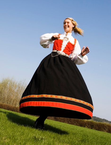 Bunadskledd ungjente svinger seg. Foto.