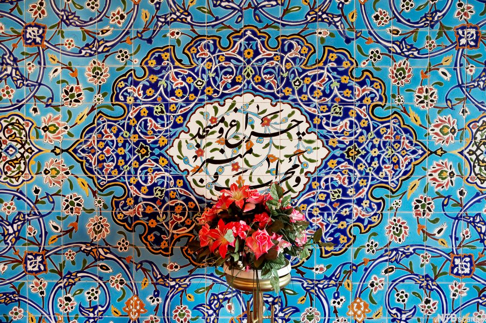 Mosaikk i blå- og gultoner og blomstervase i moské i Oslo. Foto.