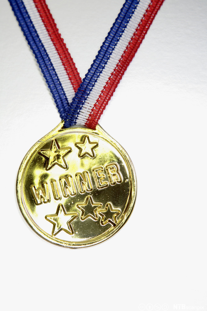 Gullmedalje med to stjerner og påskriften "Winner". Foto.