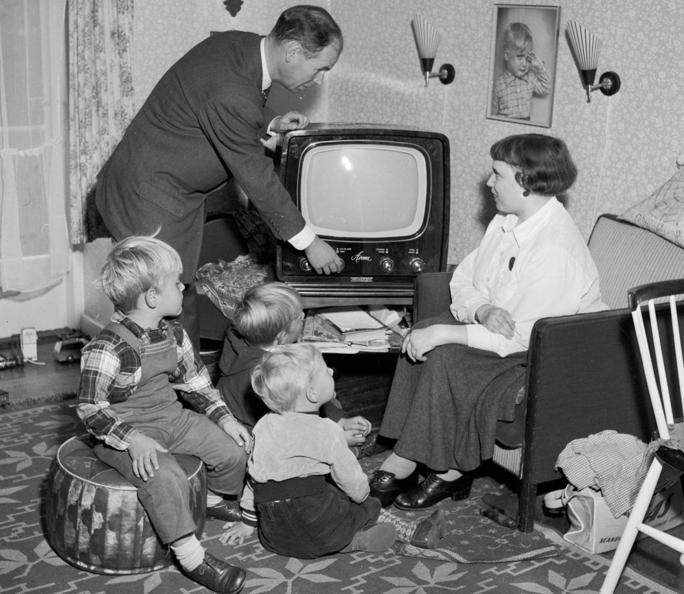 En familie er klar til å se på fjernsyn på slutten av 1950-tallet. Foto.