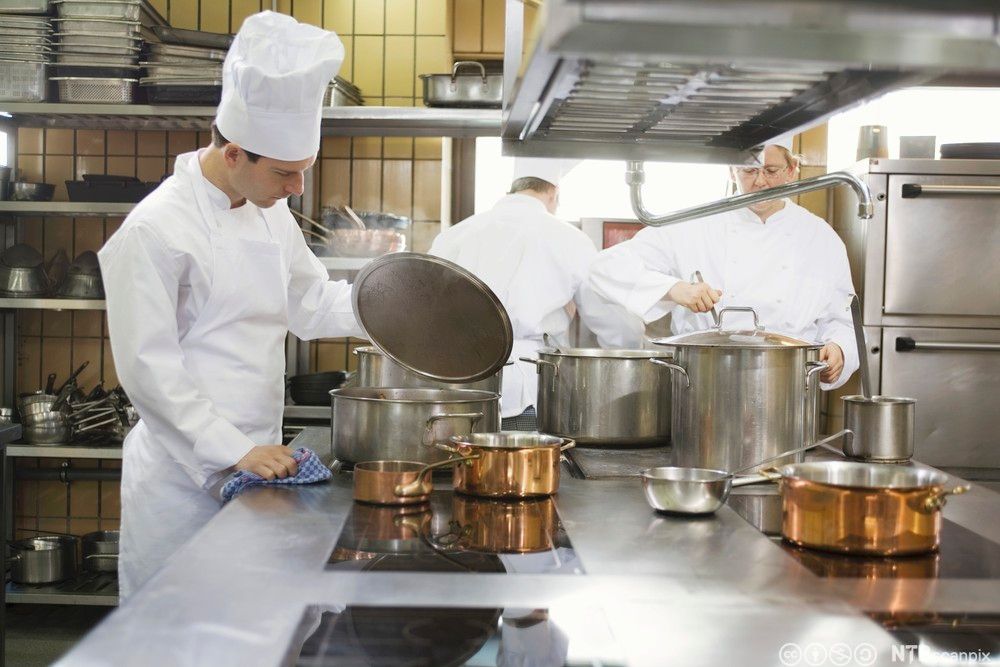 Kokker på et storkjøkken lager mat. Foto.