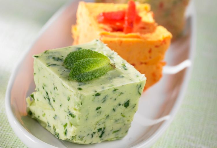 Ulike typar med kryddersmør i terningar på eit fat. Foto.