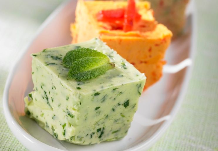 Ulike typer med kryddersmør i terninger på et fat. Foto.