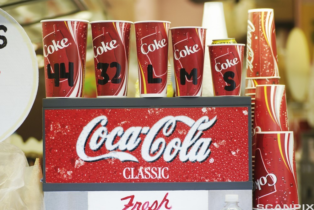 Nærbilde av en Coca-Cola-Classic-logo på en brusautomat. Foto. 