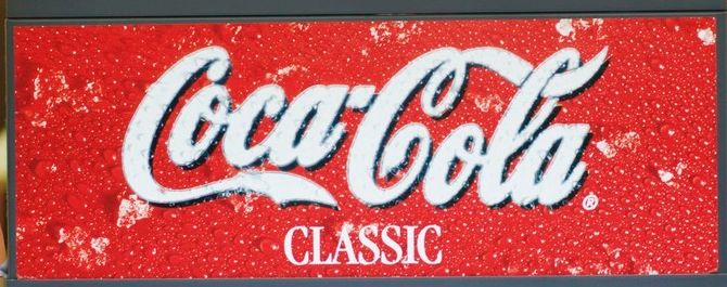 Nærbilde av en Coca-Cola-Classic-logo på en brusautomat. Foto.