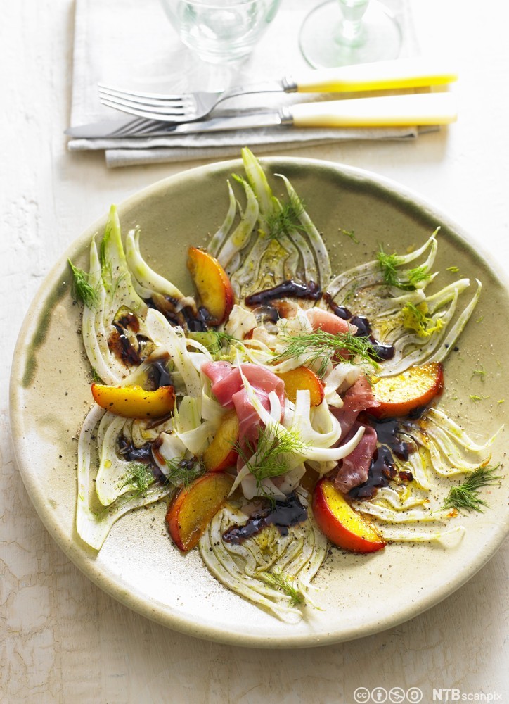 Grønnsaker, frukt og spekeskinke anrettet på tallerken. Foto.