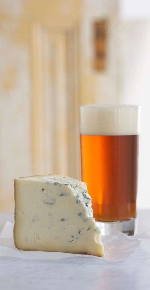 Et stykke stilton og et glass øl. Foto.