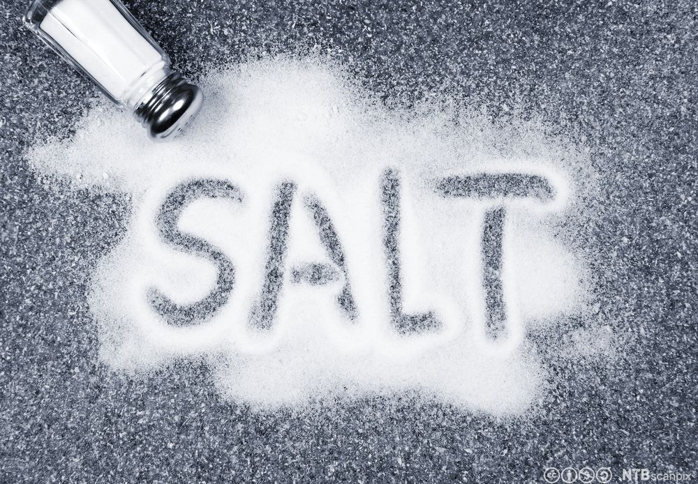 Ordet "salt" skrevet med bokstaver i en haug med salt. Foto.