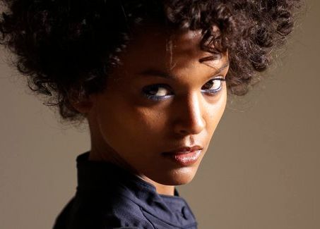 Close-up of actor and model Liya Kebede who plays Waris Dirie in the film Desert Flower. She is wearing a blue chiffon blouse. Photo.