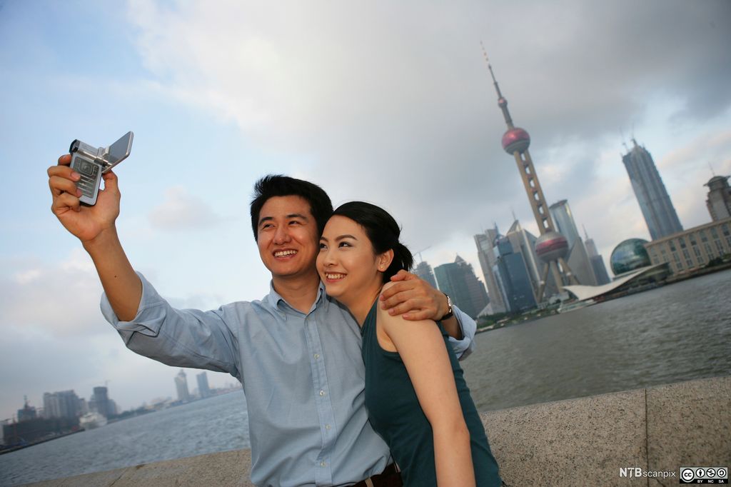 Et kinesisk par tar selfie fra Pudong med Shanghai i bakgrunnen. Foto.