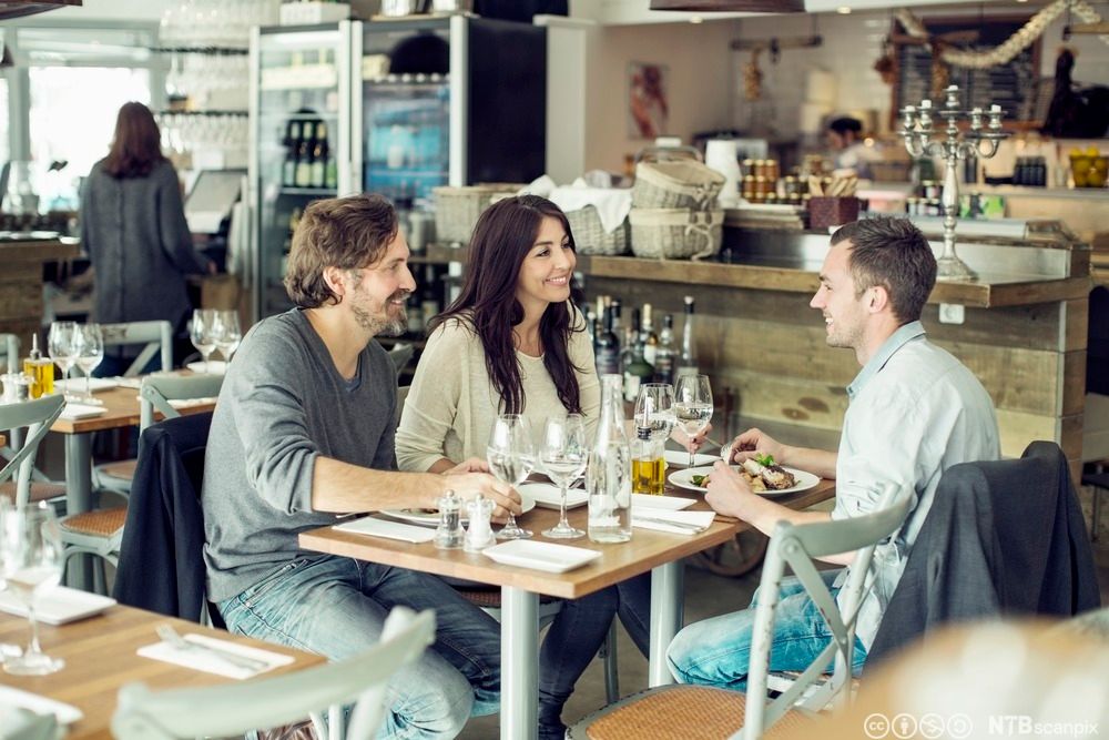 Tre gjester som spiser middag sammen på en restaurant. Foto.