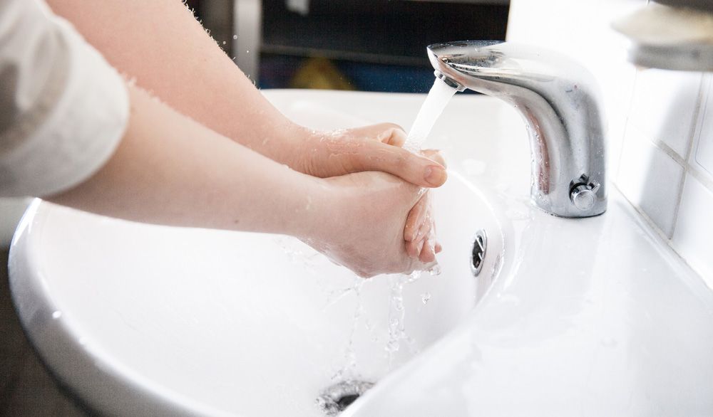 Håndvask under rennende vann. Foto.