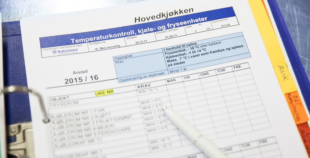 Skjema for temperaturkontroll i kjøle- og fryseenheter i hovedkjøkken, festet i en ringperm. Foto.