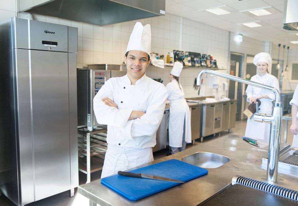 Kokk ved arbeidsstasjon. Foto.