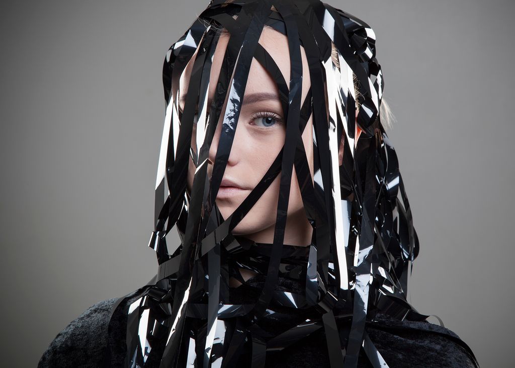 Portrett av modell med svarte remser foran ansiktet. Foto.