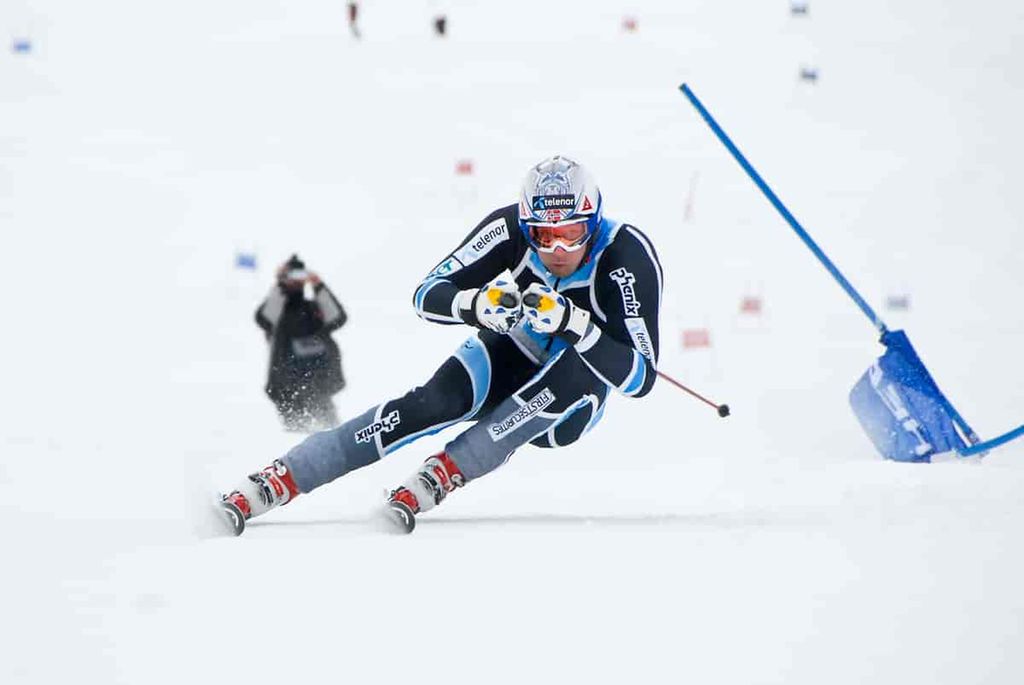 Alpinist i full fart ned en bakke. Foto.