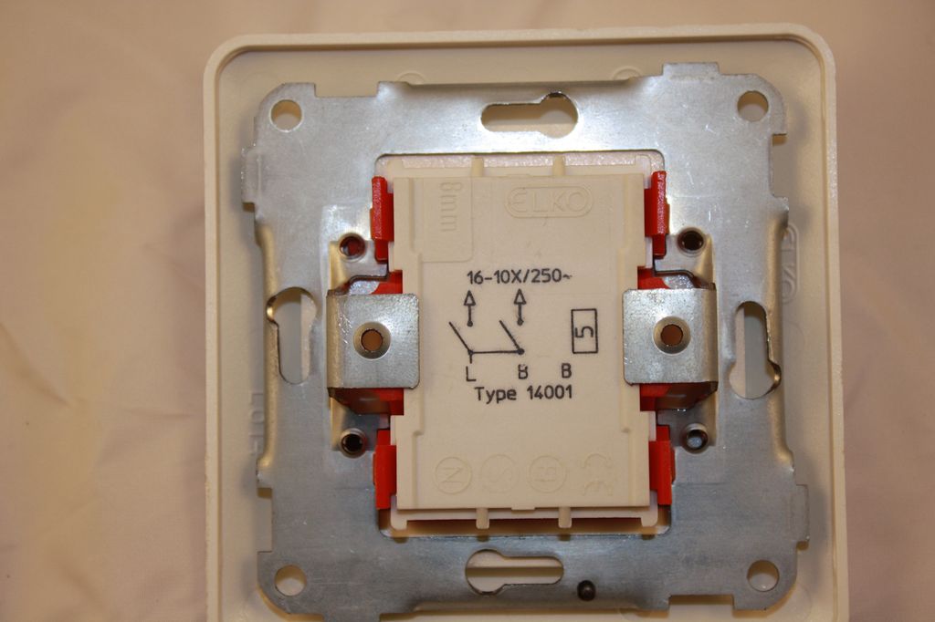 Baksiden av en serievender, innfelt bryter. Symbolene indikerer hvordan den skal kobles. Foto.