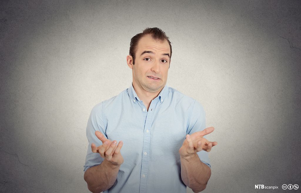 Mann gestikulerer med hendene. Foto.