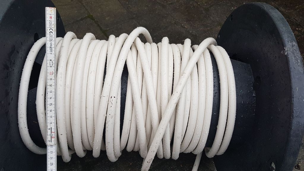 Trommel med elektrisk kabel. Det er att 33 kveilar med kabel på trommelen. Ein tommestokk er lagt på trommelen. Han viser at tverrsnittet på kveilane går frå cirka 5 cm på tommestokken til cirka 22 cm. Foto.