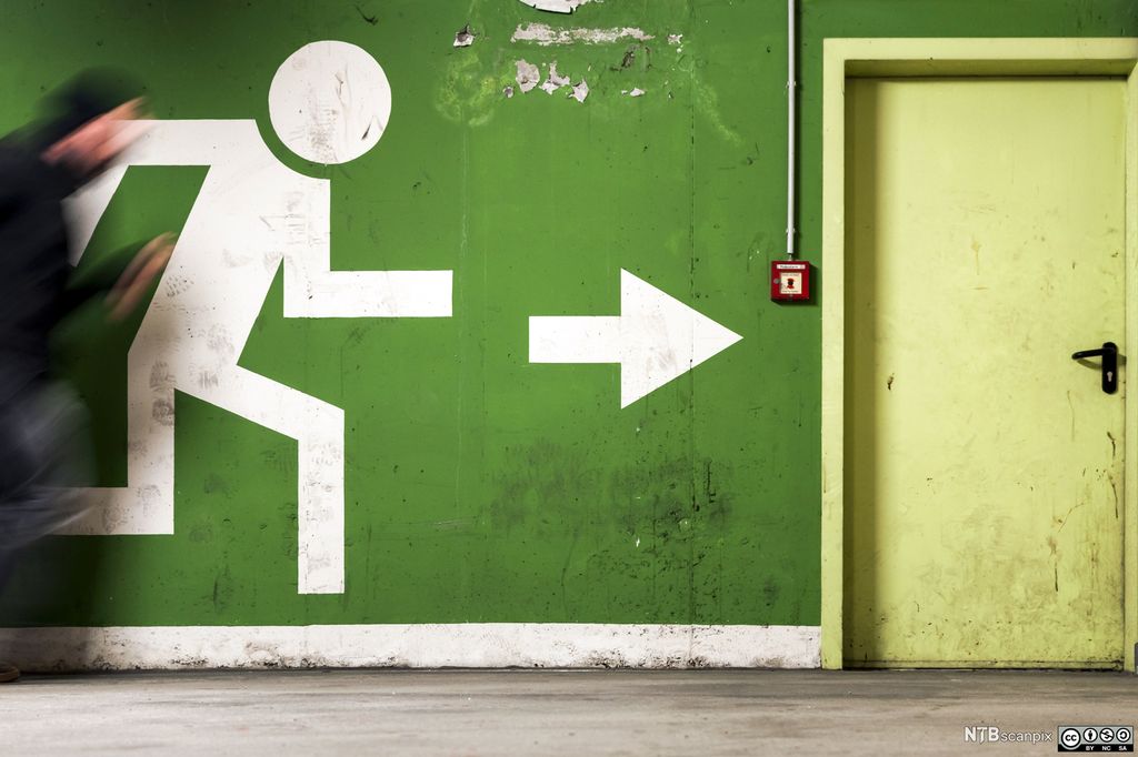 Figur løper mot nødutgangen. Illustrasjon.