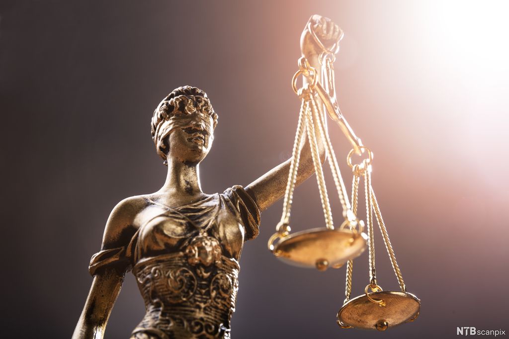 Kvinnefigur som holder en vekt med vektskåler. Hun har bind for øynene. Foto.